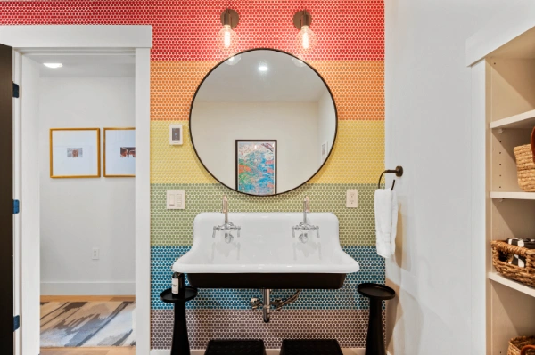 Close-up of illuminated “Mile Away Stowe” neon sign casting soft purple light across the kids loft wall